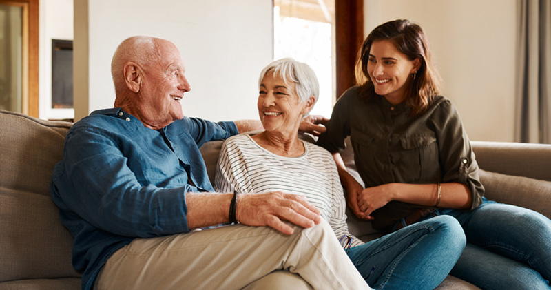 An adult woman spends quality time with her mother and father, something that many only children do when providing care for an aging parent.