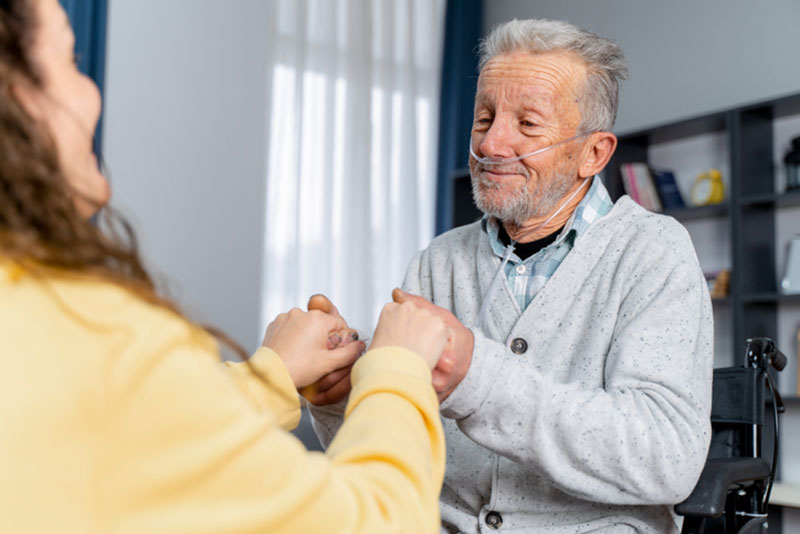A woman helps her aging father with managing COPD symptoms at home.